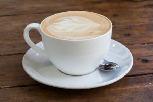 Latte art coffee over wooden background