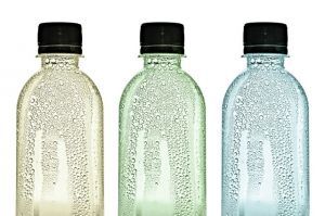 Three plastic bottles with water drops on skins