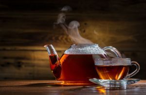 glass teapot and mug on the wooden background