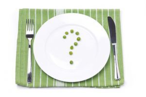 empty plate with green peas in the shape of a question mark