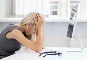 Overworked and tired young woman in front of computer