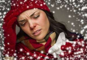 Sick Mixed Race Woman Wearing Winter Hat and Gloves  with a Tissue and Snow Effect Surrounding Her.