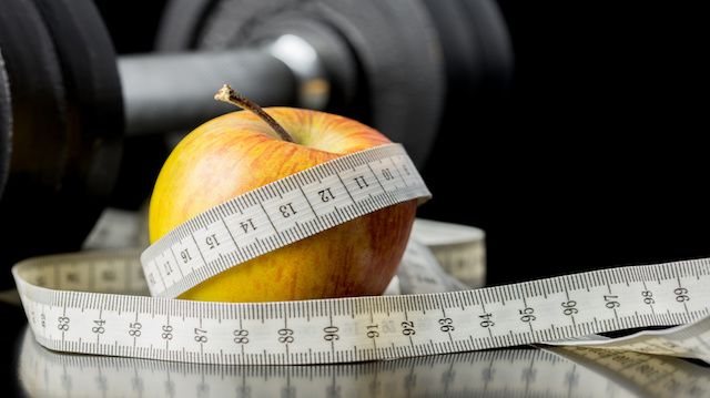 Fresh juicy apple wrapped in a tape measure