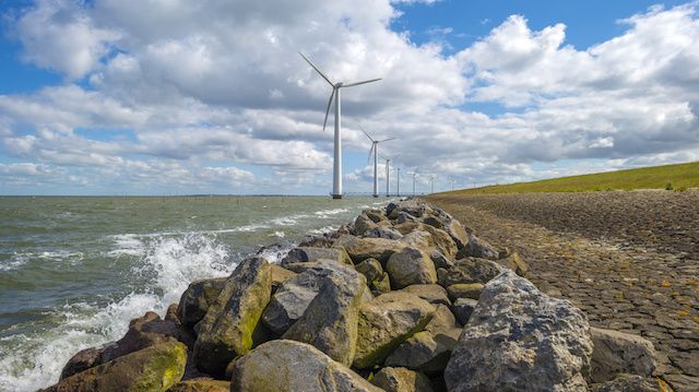 Wind farm in water along a dike in spring