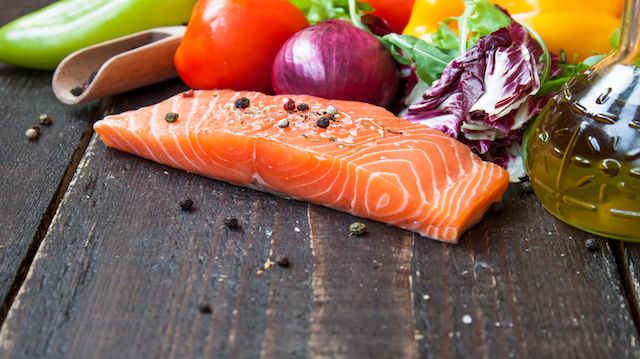 fresh salmon with vegetables on a wooden table