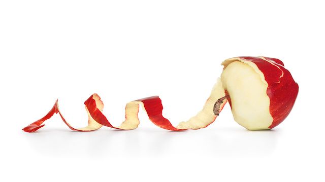 red apple with peeled skin isolated on white background