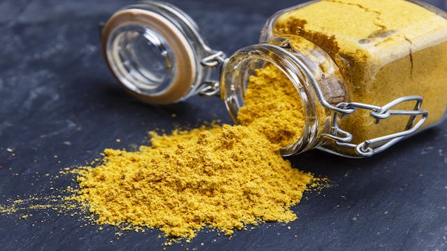 powder seasoning spice turmeric on a black stone