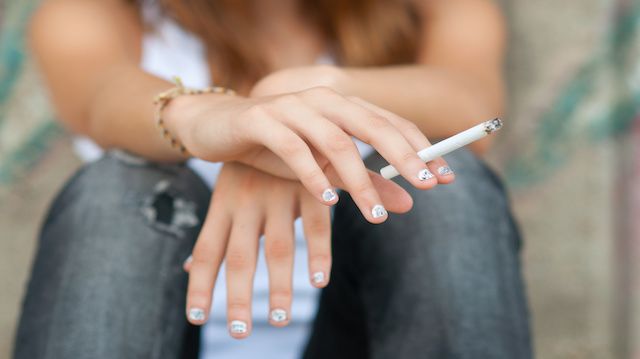 Teenage hands holding cigarette