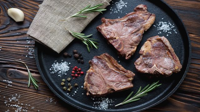 Above view of a frying pan with grilled T-bone lamb steaks