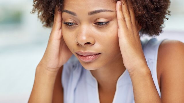 close up of african young woman touching her head