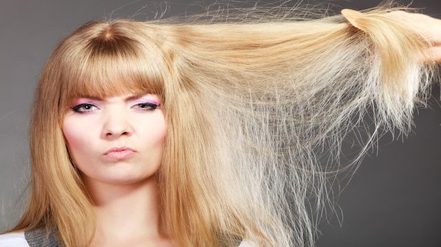 Blonde woman with her damaged dry hair.