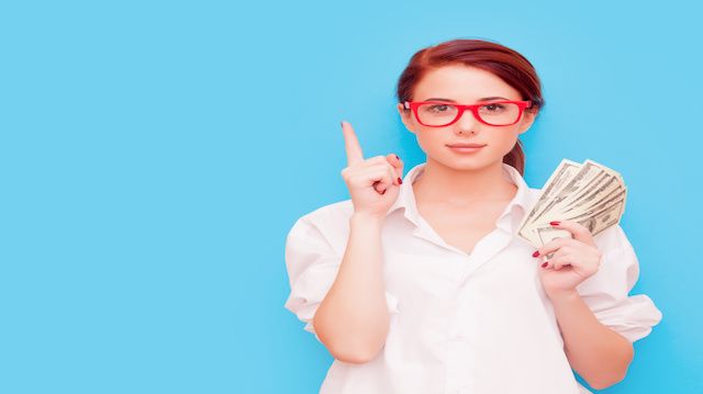 Portrait of redhead woman in red glasses with money