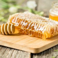 Honeycomb on wooden board with honey spoon