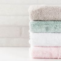 Spa relax and bath concept, stack clean bath towels colorful cotton terry textile in bathroom white background, copy space top view