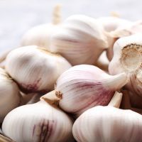 Garlic in basket on grey wooden table