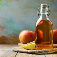 Apple vinegar. Bottle of apple organic vinegar or cider on wooden background. Healthy organic food. With copy space