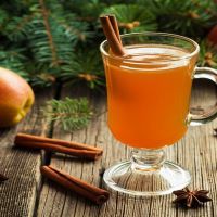 Hot apple cider traditional winter season drink with cinnamon and anise. Homemade healthy organic warm spice beverage. Christmas or thanksgiving holiday decoration on vintage wooden background.