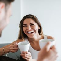 Laughing couple drinking coffee in the morning.