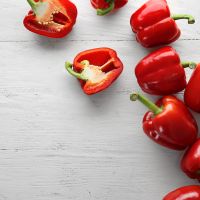 Ripe red peppers on white wooden background
