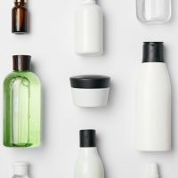 Top view of different cosmetic bottles and container on white background