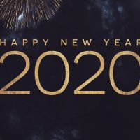 Happy New Year 2020 Text with Gold Fireworks in Night Sky