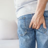 Young man has pain in the butt, Hemorrhoids, Anal disorders.